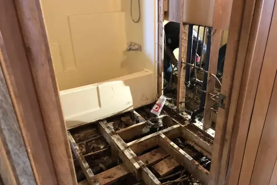 Bathroom floor decking cut open down to the joists in a manufactured home after a leak